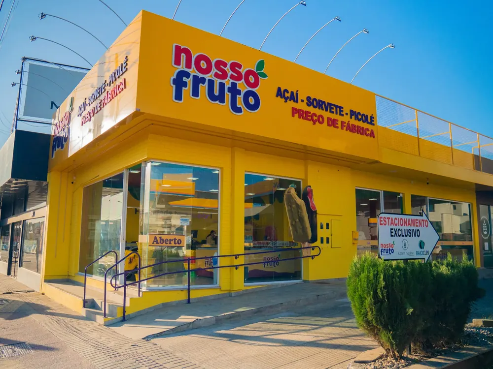 Fachada amarela de uma loja Nosso Fruto — Açaí, Sorvete e Picolé